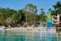 Girls jumping in sea in Jamaica